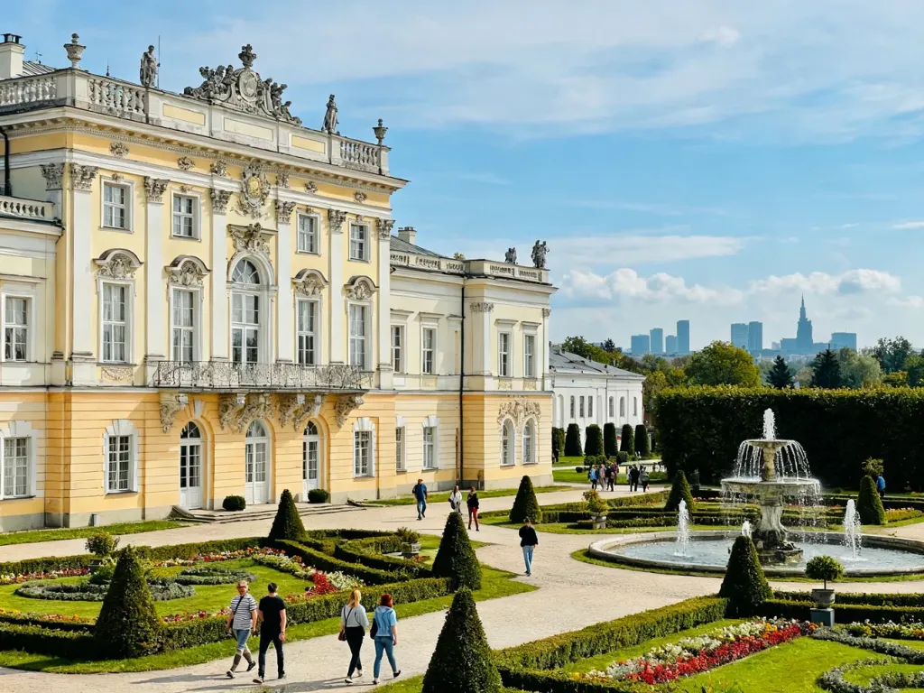 Pałac Branickich w Białymstoku z barokowymi ogrodami i spacerującymi turystami w słoneczny dzień, no text on the picture